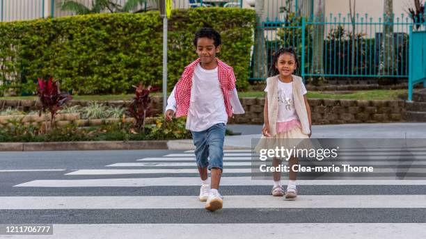 male child and female child crossing the road - crossed stock pictures, royalty-free photos & images