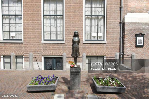 Flowers laid at the Anne Frank statue near Anne Frank house on empty street during the Remembrance Day to celebrate 75 Years of the War victims amid...