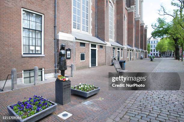 Flowers laid at the Anne Frank statue near Anne Frank house on empty street during the Remembrance Day to celebrate 75 Years of the War victims amid...