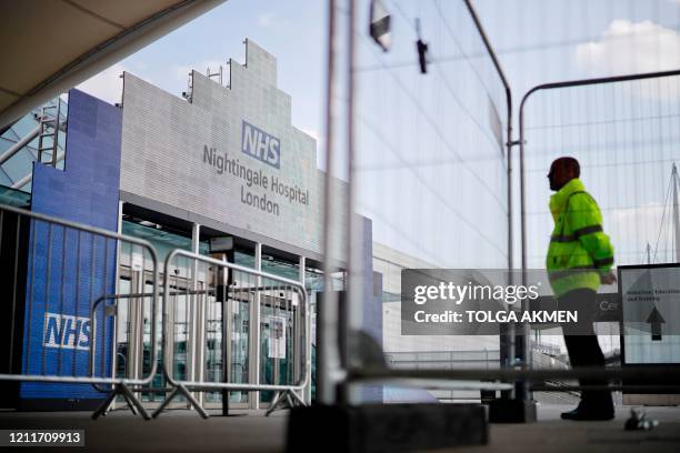 Security guard stands at a barrier outside the NHS Nightingale Hospital London on May 4, 2020 set up at the ExCel London exhibition and convention...