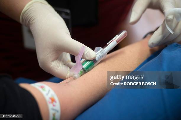 Volunteer gets blood drawn while waiting to be injected, at the start of a clinical trial being set up by TASK, a clinical research organisation...