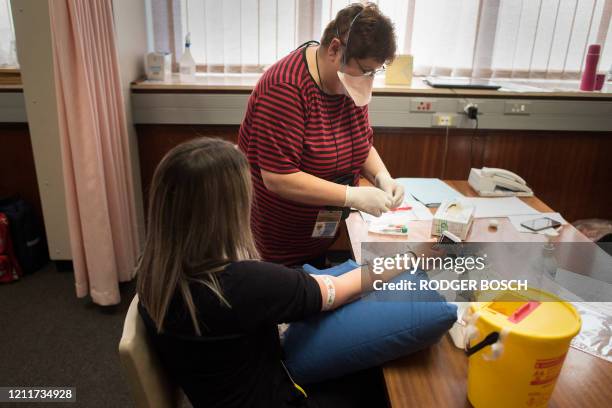 Michelle van Rooyen , a staff member gets ready to take a blood sample from a volunteer at the start of a clinical trial being set up by TASK, a...