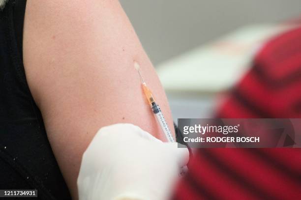Volunteer is injected with a syringe containing either the vaccine or a placebo, at the start of a clinical trial being set up by TASK, a clinical...