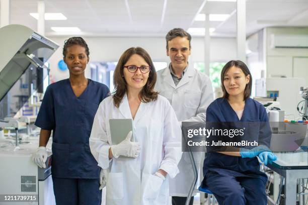 group photo of professional colleagues working together in clinical analysis laboratory - medical laboratory stock pictures, royalty-free photos & images