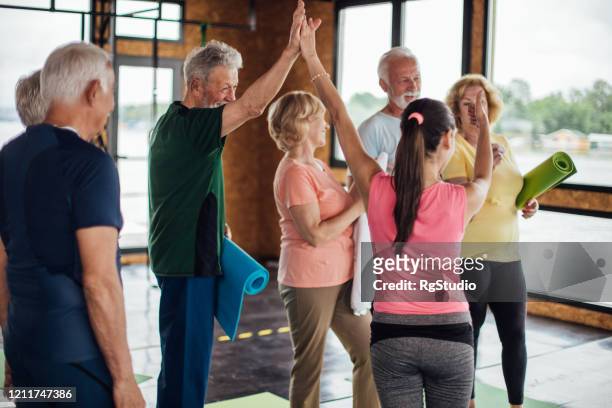 group of happy seniors after their yoga class - practising tai-chi stock pictures, royalty-free photos & images