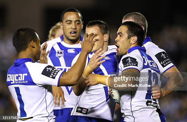 Dene Halatau of the Bulldogs is congratulated by his team mates after scoring a try during the round 23 NRL match between the Cronulla Sharks and the...