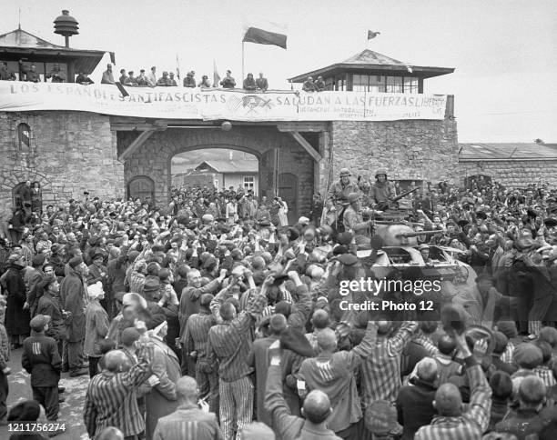 Tanks of U.S. 11th Armoured Division entering the Mauthausen concentration camp;banner in Spanish reads 'Antifascist Spaniards greet the forces of...