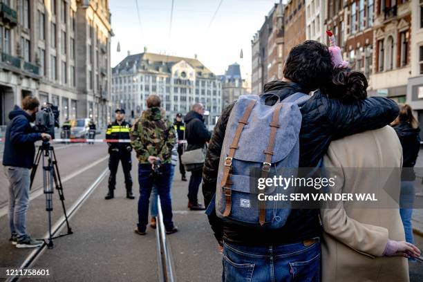 Pedestrian stand in front of a cordon set up by the police on Damrak street during a wreath-laying ceremony attended by the King and Queen of the...