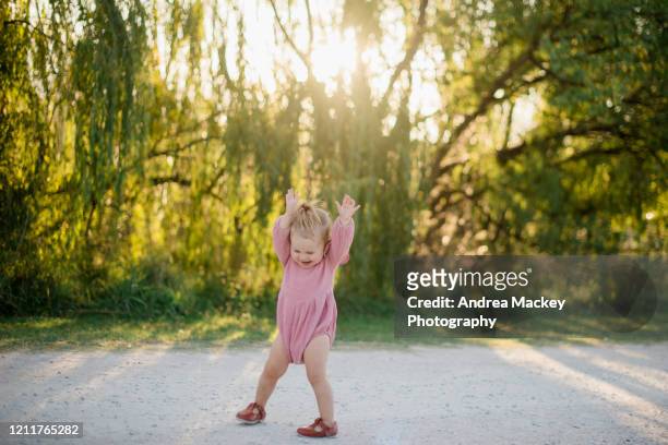baby girl playing on dirt road at sunset - pink shoe fotografías e imágenes de stock