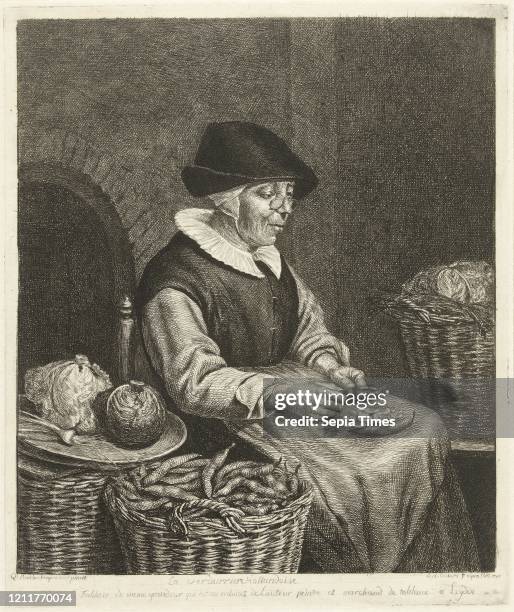 An old woman sitting in the kitchen on a chair and blanked beans in her apron, beside her are baskets of coal, praise and beans, the woman is wearing...