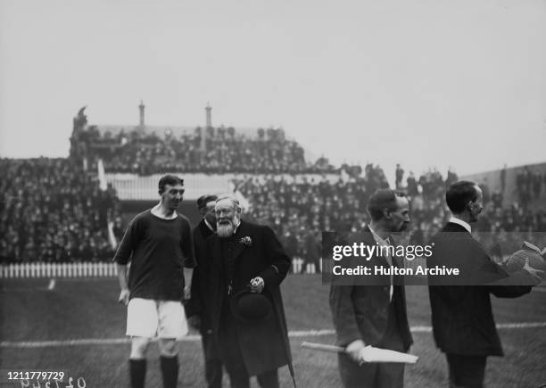 Arthur Kinnaird, 11th Lord Kinnaird , principal of The Football Association, talking to a soccer player during a match at a stadium, UK, circa 1910.