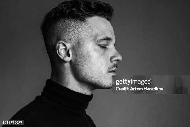 handsome young man with undercut hairstyle in profile view - male eyes stock pictures, royalty-free photos & images