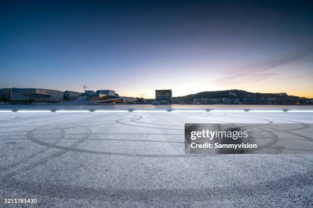 road against urban skyline - norway landscape stock-fotos und bilder