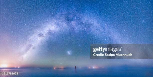 panorama of a man photograph the milky way over the sky at uyuni salt flat, bolivia - uyuni stock pictures, royalty-free photos & images