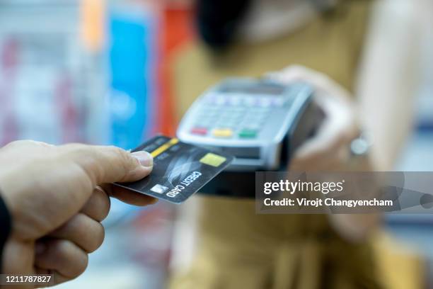 customer hands paying by credit card with a credit card reader machine - man check suit stock-fotos und bilder