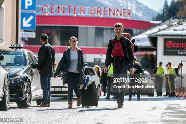 Couple from Germany cross the border between Austria and Italy after arriving at the Brenner Pass near Matrei am Brenner on March 11, 2020 near...