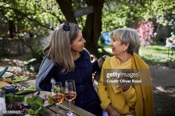 two women talking on a garden party - senior women wine stock pictures, royalty-free photos & images