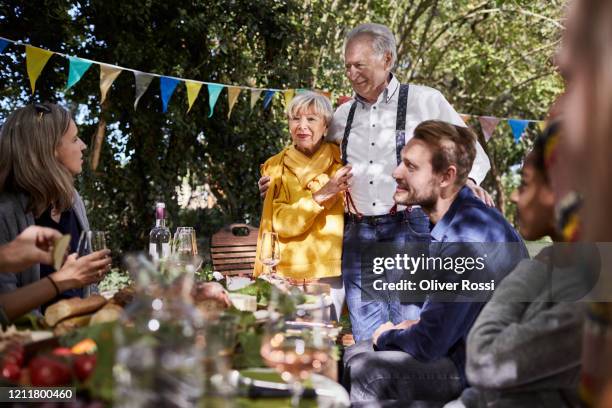 happy senior couple hosting a garden party - loyalität stock-fotos und bilder