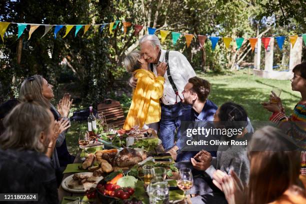 happy senior couple hosting a garden party - familienfeier stock-fotos und bilder