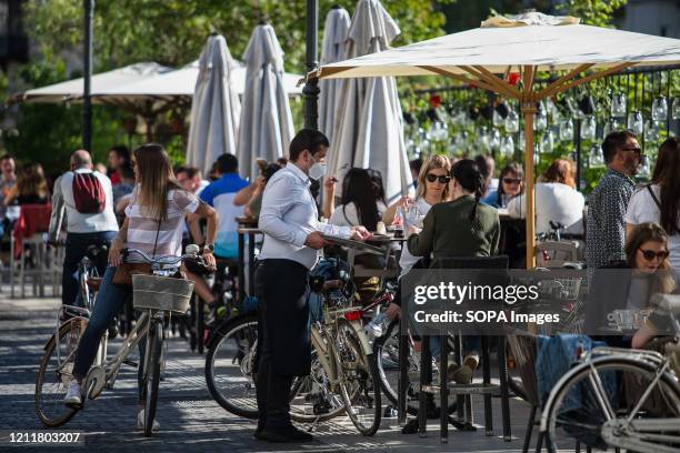 People relax on the outdoor terrace cafe shop at the city center as Slovenia eases its lockdown. Outdoor terrace bars, restaurants along with beauty...