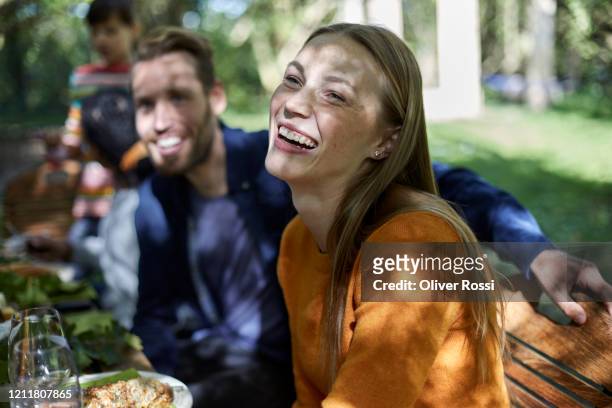 portrait of a laughing young woman on a garden party - outdoor dining 個照片及圖片檔
