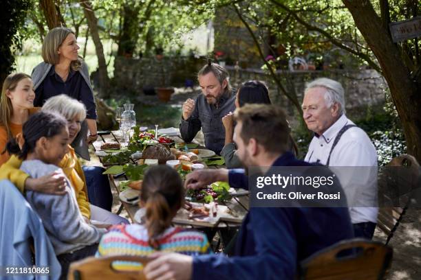 family having a garden party dining al fresco - family meeting stock pictures, royalty-free photos & images