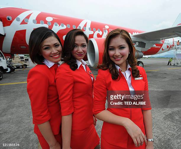 Cabin crew of AirAsia pose next to the company's new Airbus A320 passenger aircraft shortly after arriving from Toulouse, France at Clark airport in...