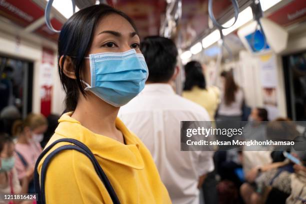 masked girl to protect herself from covid 19 virus in public area - coronavirus mask stock pictures, royalty-free photos & images