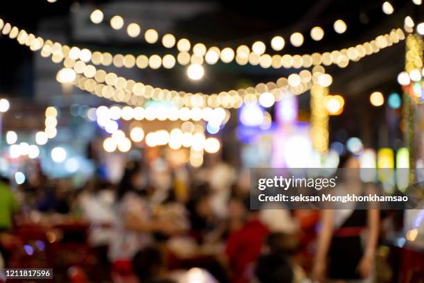 wood bar table with blur lighting in night street cafe - street light fotografías e imágenes de stock