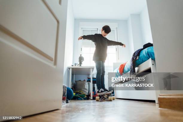 10 year old boy with skate in the room - messy room stock pictures, royalty-free photos & images