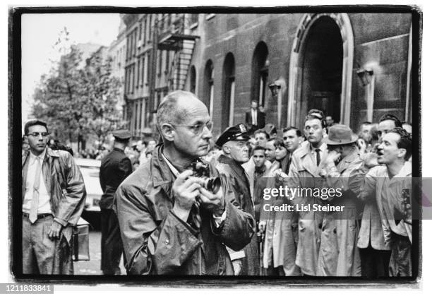 View of French photojournalist Henri Cartier-Bresson stands with a crowd outside Harlem's Hotel Theresa, New York, New York, 1960. He, and the crowd,...