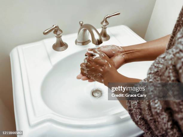 woman washes hands - パウダールーム　女性 ストックフォトと画像