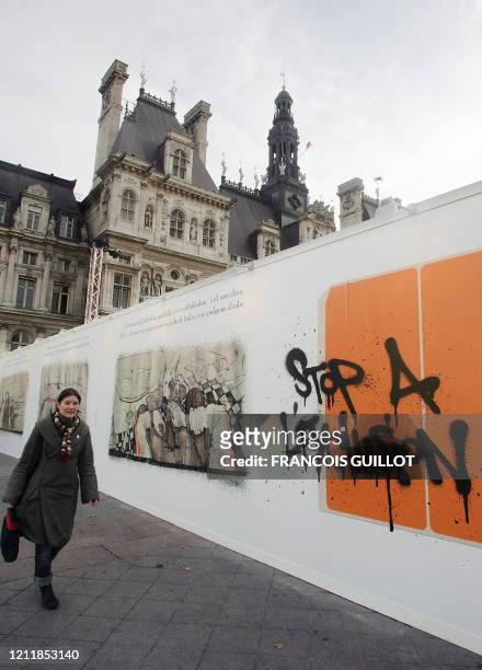 Une femme passe le 01 décembre 2006, devant une fresque contre les discriminations inaugurée sur le parvis de l'Hôtel de Ville à Paris. La fresque de...