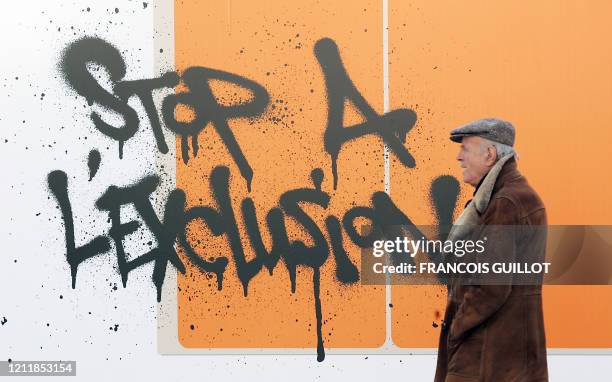 Un homme passe le 01 décembre 2006, devant une fresque contre les discriminations inaugurée sur le parvis de l'Hôtel de Ville à Paris. La fresque de...