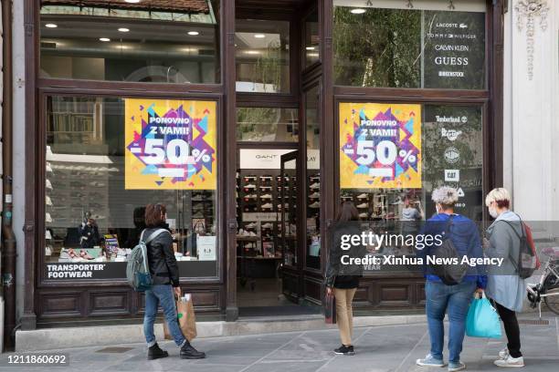 May 4, 2020 .People stand outside a shoe store in Ljubljana, Slovenia, on May 4, 2020. More services are available to Slovenians on Monday as...