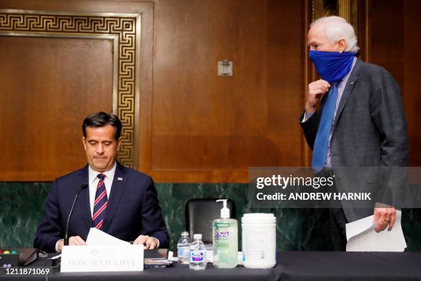 Rep. John Ratcliffe, R-TX, reviews his papers as Sen. John Cornyn, R-TX walks up, at the top of a Senate Intelligence Committee nomination hearing on...