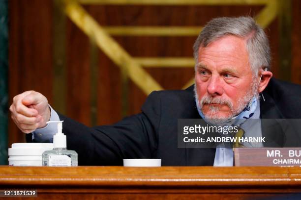 Chairman Richard Burr, R-NC, reaches for hand sanitizer at a Senate Intelligence Committee nomination hearing for Rep. John Ratcliffe, R-TX, on...