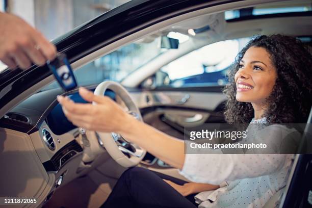 car dealer is giving key for a new car to a businesswoman - luxury cars stock pictures, royalty-free photos & images