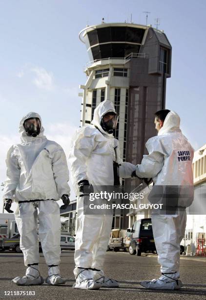 Des sapeurs-pompiers s'équipent de tenues NBC lors d'un exercice nucléaire, radiologique, bactériologique et chimique le 09 janvier 2005 à l'aéroport...