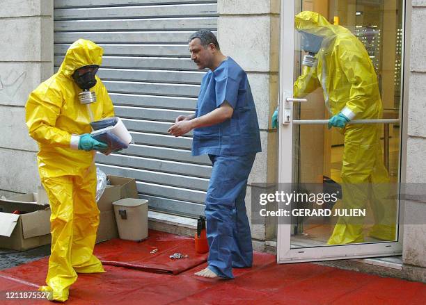 Des marins-pompiers en tenue de protection bactériologique prennent en charge les personnes qui se trouvaient dans le magasin où a été trouvé une...