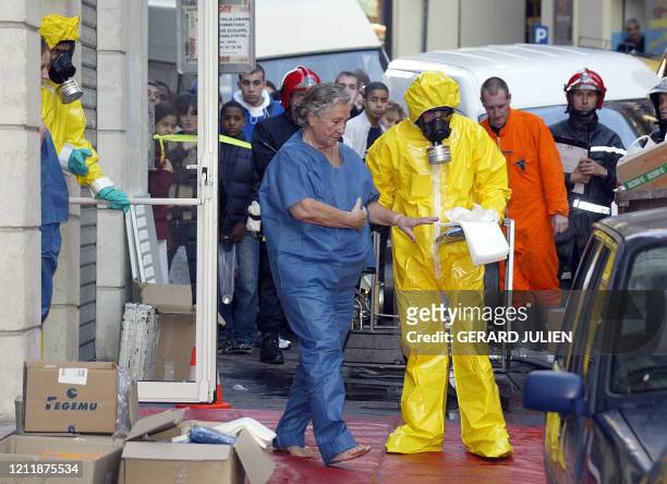 Des marins-pompiers en tenue de protection bactériologique prennent en charge les personnes qui se trouvaient dans le magasin où a été trouvé une...