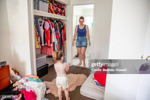 australian mother of two young children in her family home participating in domestic life activities - childrens closet stock pictures, royalty-free photos & images