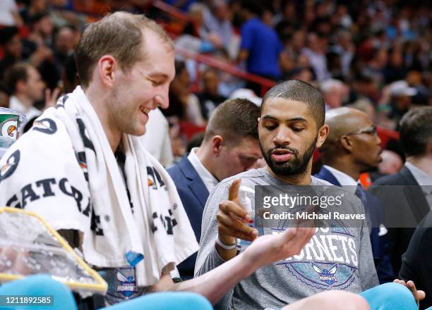 Nicolas Batum of the Charlotte Hornets gives Cody Zeller hand sanitizer during the second half against the Miami Heat at American Airlines Arena on...