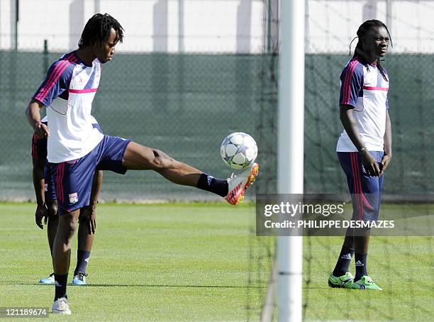 Lyon's Burkinabe defender Kone Bakary plays with the ball next to French forward Bafetimbi Gomis during a training session on the eve of the UEFA...