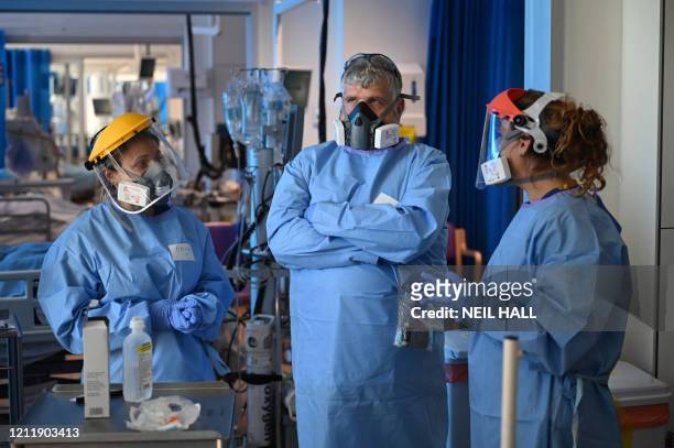 Members of the clinical staff wear personal protective equipment as they care for patients at the Intensive Care unit at Royal Papworth Hospital in...