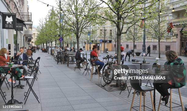 People sit outside a cafe in Vilnius, Lithuania, on May 5 amidst the new coronavirus COVID-19 pandemic. - The Lithuanian government extended the...