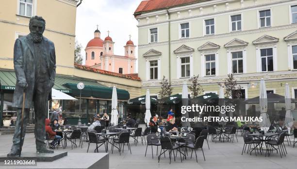 People sit outside a cafe in Vilnius, Lithuania, on May 5 amidst the new coronavirus COVID-19 pandemic. - The Lithuanian government extended the...