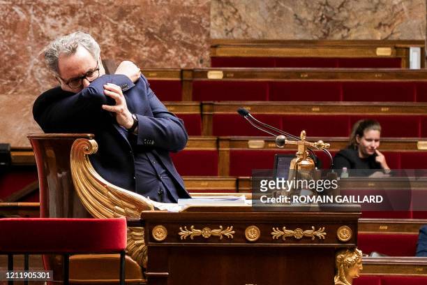 The President of the French National Assembly Richard Ferrand sneezes as he chairs a session of questions to the government at the National Assembly...