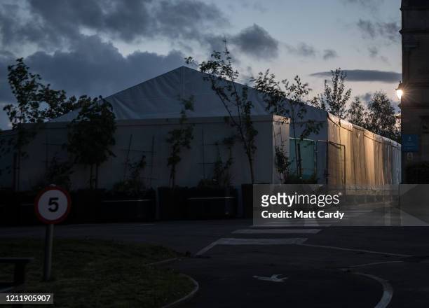Night falls on a temporary morgue that has been constructed on the grounds of Haycombe Cemetery to accommodate victims of COVID-19 on May 1, 2020 in...