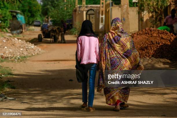 Sudanese women walk in the capital Khartoum's district of Jureif Ghar on May 5, 2020. - Sudan's cabinet approved amendments to the criminal code that...